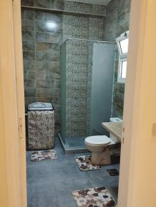 a bathroom with a toilet and a shower with mats at Hurghada's Marina view in Hurghada