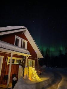 una casa con la aurora bailando en el cielo en Apartment Neitamo44, en Ivalo