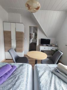 een kamer met 2 bedden en een tafel en stoelen bij Gästehaus im Alten Fährhaus in Cochem