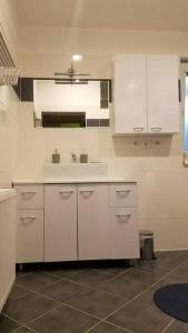 a kitchen with white cabinets and a sink at Apartmán Stella in Prostějov