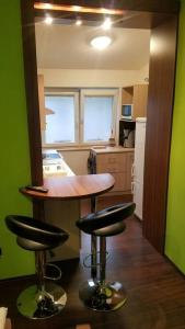 a kitchen with a table and two bar stools at Apartmán Stella in Prostějov
