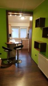 a kitchen with green walls and a table and stools at Apartmán Stella in Prostějov