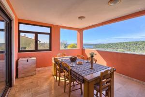 a dining room with a table and chairs and windows at Apartment Fran in Banjole