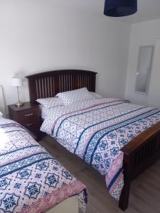 a bedroom with two beds and a table with a lamp at Sunny Side - Self Catering Accommodation Gorey in Gorey