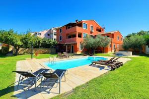 a swimming pool with chairs and a house at Apartment Fran in Banjole