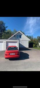 un coche rojo estacionado frente a un garaje en Comfy Cozy Room in beautiful home, en Luleå