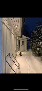 a snow covered porch of a building with a snow shovel at Comfy Cozy Room in beautiful home in Luleå
