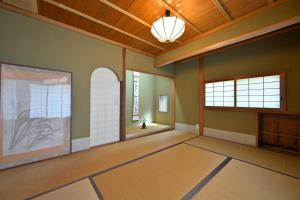 um quarto vazio com uma grande janela e um tecto em 島の風景に溶け込む、日本の伝統旅館「かんなから」 em Tonosho