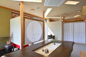 ein Esszimmer mit einem Tisch und einem großen Fenster in der Unterkunft 島の風景に溶け込む、日本の伝統旅館「かんなから」 in Tonosho