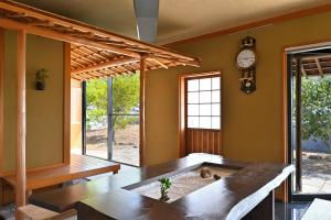 ein Wohnzimmer mit einem Tisch und einer Uhr an der Wand in der Unterkunft 島の風景に溶け込む、日本の伝統旅館「かんなから」 in Tonosho