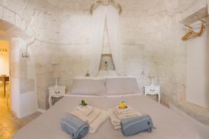 a bedroom with a bed with towels on it at Trulli Harmonia con piscina - Alberobello in Alberobello
