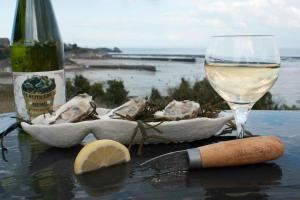 una mesa con una botella de vino y una copa en Proche St-Malo, plages, appart 50m2 avec jardin, en Dinard