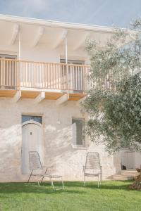 two chairs in the grass in front of a house at Trulli Harmonia con piscina - Alberobello in Alberobello