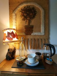 einen Tisch mit einer Kaffeekanne, einer Tasse und einer Lampe in der Unterkunft Le Clos des Fayes in Berthegon