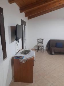 a living room with a tv and a couch at Appartamento centro in SantʼAntìoco