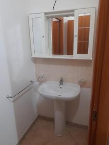 a bathroom with a white sink and a mirror at Appartamento centro in SantʼAntìoco