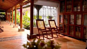 a row of chairs in a library with bookshelves at Hotel Villa de Mompox in Mompos
