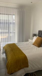 a bedroom with a large bed with a large window at CALDESMO - Upmarket Apartment in Pretoria