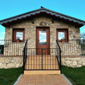 uma casa de pedra com uma porta e duas janelas em El naval de la Parra II em Sejas de Sanabria