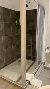 a shower with a glass door in a bathroom at CALDESMO - Upmarket Apartment in Pretoria