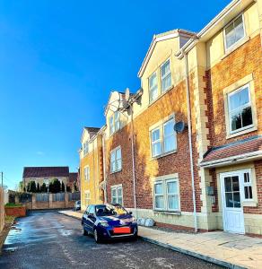 a blue car parked in front of a brick building at Two bedroom Entire Apartment in Roman road with Free Parking in Middlesbrough