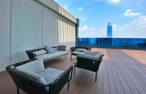 einen Balkon mit Stühlen und Sofas auf einem Gebäude in der Unterkunft Amazing KLCC SKY view infinity pool Eaton Residences Suites in Kuala Lumpur