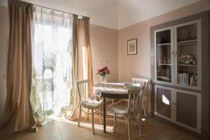 ein Esszimmer mit einem Tisch, Stühlen und einem Fenster in der Unterkunft C'ERA UNA VOLTA - casa vacanza Etna-Sicilia-mare in Linguaglossa