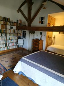 a bedroom with a bed and book shelves at Le Clos des Fayes in Berthegon