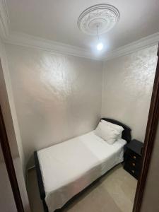 a small bedroom with a white bed and a light at Fully equipped ground floor apartment in Safi