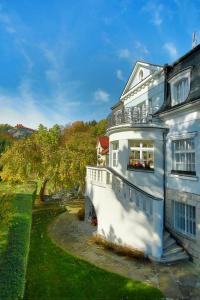 een wit huis met een balkon aan de zijkant bij Pension Harmonie in Hrubá Skála