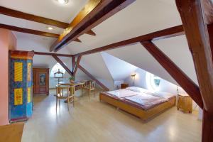 a attic bedroom with a bed and a table at Pension Harmonie in Hrubá Skála