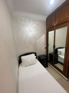 a bedroom with a white bed and a mirror at Fully equipped ground floor apartment in Safi