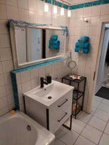 e bagno con lavandino, specchio e vasca. di Wohnung im Dreistädteeck a Norimberga