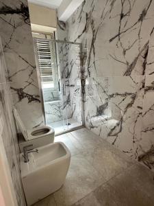 uma casa de banho com um WC branco e um lavatório. em Giramondo apartment centrale em Milão