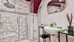 La salle de bains est pourvue d'un lavabo et d'une douche. dans l'établissement Colosseum Charme Apartments, à Rome