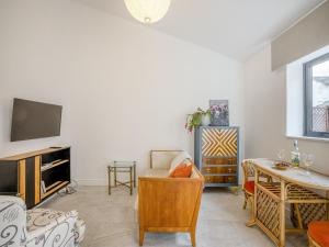 ein Wohnzimmer mit einem TV und einem Tisch in der Unterkunft Angeliki - Uk43588 in Ellesmere