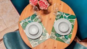 - une table en bois avec 2 assiettes et des verres à vin dans l'établissement Colosseum Charme Apartments, à Rome