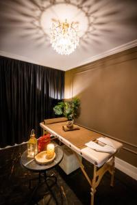 uma sala de jantar com uma mesa e um lustre em Amber Park Spa em Niechorze