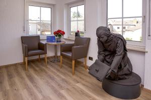 Eine Statue einer Frau, die auf einem Tisch in einem Wartezimmer sitzt in der Unterkunft Keller Höhe in Andernach