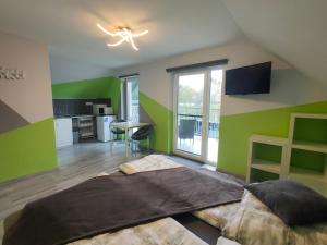 a bedroom with green walls and a bed with a desk at Kikapcs apartman in Alsóörs
