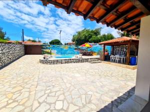 eine Terrasse mit einem Pool und einem Pavillon in der Unterkunft Casa Temporada Praia Carapibus 200m Da Praia in Conde