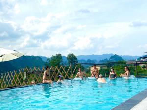 un gruppo di persone sedute in piscina di Zhangjiajie National Park Nvue Resorts a Zhangjiajie
