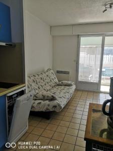 a living room with a couch and a window at LES OCEANIDES in Brétignolles-sur-Mer