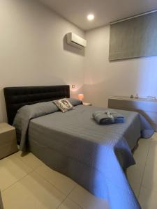 um quarto com uma cama com um cobertor azul em Casa Marina em Sciacca