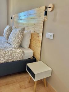a bed with a wooden headboard next to a table at The Globetrotter's Inn in Ericeira