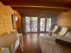 een slaapkamer met een bed en stoelen in een blokhut bij CabanaLanz, Cabañas en Lanzarote in San Bartolomé