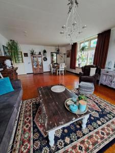 a living room with a table and a couch at aan de schulpvaart in Limmen