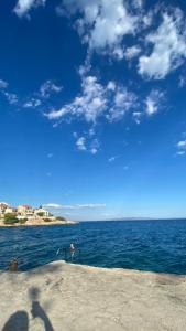 a large body of water with a blue sky and clouds at L&L in Okrug Gornji