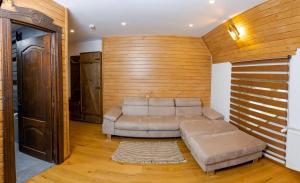 sala de estar con sofá y pared de madera en Conacul Drahneilor, en Ruscova