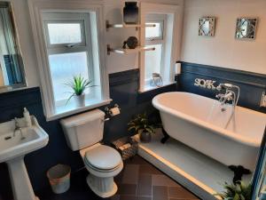 uma casa de banho com uma banheira, um WC e um lavatório. em Lytham Luxury em Saint Annes on the Sea